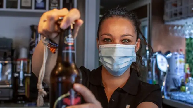 Una camarera sirve una cerveza