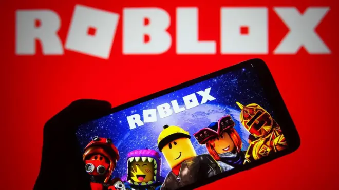 Dalam ilustrasi foto ini, logo Roblox dari platform game online terlihat di ponsel pintar dan layar komputer. 