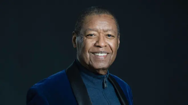 Ron Kenoly wear one dark blue blazer with one blue sweat shirt