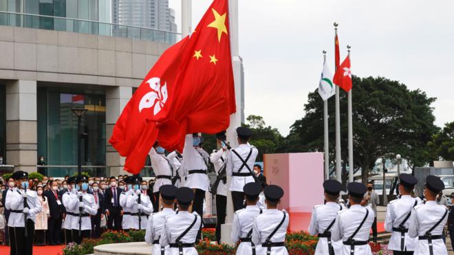 Police officers raise Chinese and Hong Kong flags during a flag-raising ceremony marking the 24th anniversary of the former British colony"s return to Chinese rule, on the 100th founding anniversary of the Communist Party of China, in Hong Kong, China July 1, 2021
