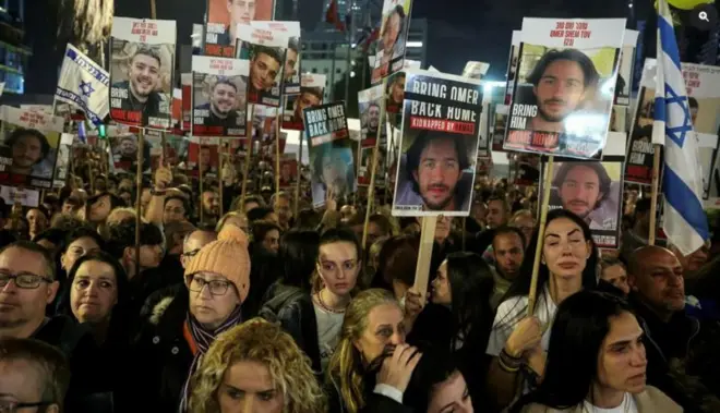 رجال ونساء يحملون لافتات احتجاج