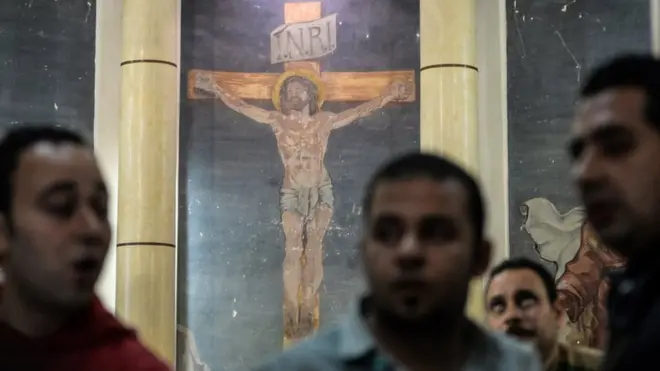 People gathered to view the damages at the scene of a bomb explosion inside Mar Girgis church in Tanta