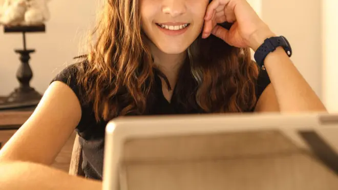 Bir çocuk bilgisayara bakıyor, yüzünün yarısını görüyoruz.