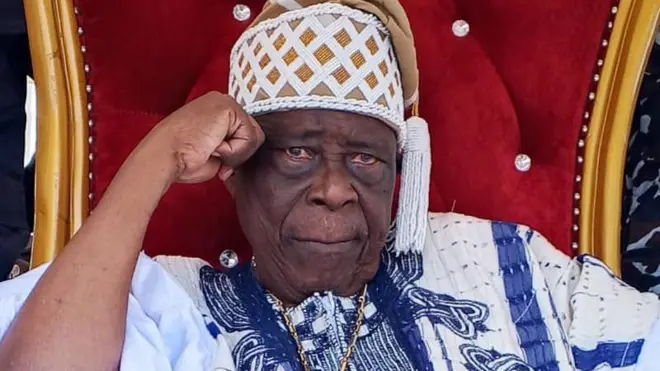 Ogiyan ti ilu Ejigbo, Ọba Omowonuola Oyeyode fi ọwọ si ẹgbẹ ori, o n wo ọọkan