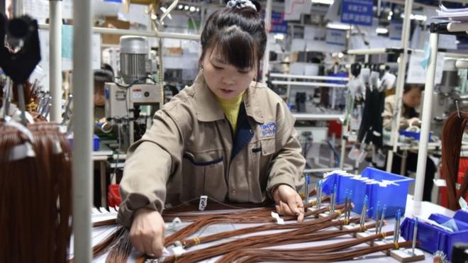 在中国中部安徽省阜阳市的一家汽车零部件工厂，一名女工正在组装汽车线束。