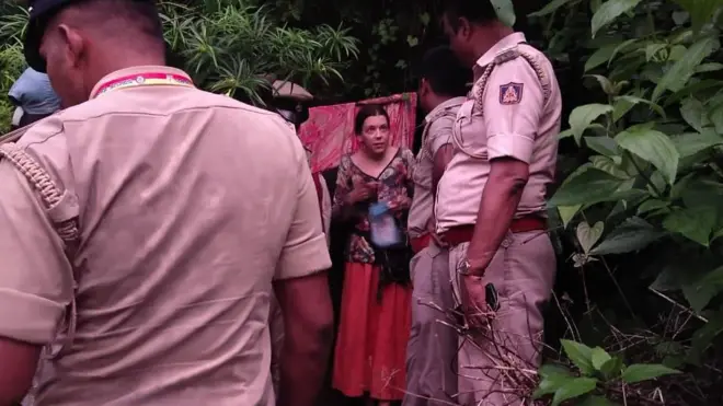 Policías hablando con una mujer rusa que se encuentra fuera de una cueva.