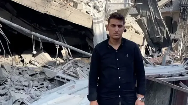 Abdelhakim dey by di destroyed remains of im home