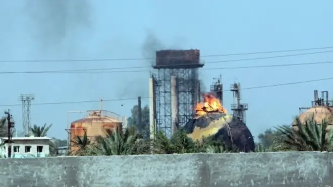 Flames and smoke rise from tanks after a suicide bomb attack on the Taji gas plant.