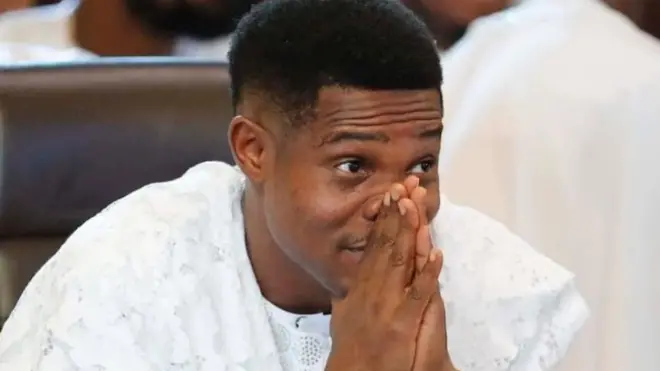 Pasitọ Jerry Eze wọ agbada funfun, o si fi ọwọ mejeeji rẹ si agbọn