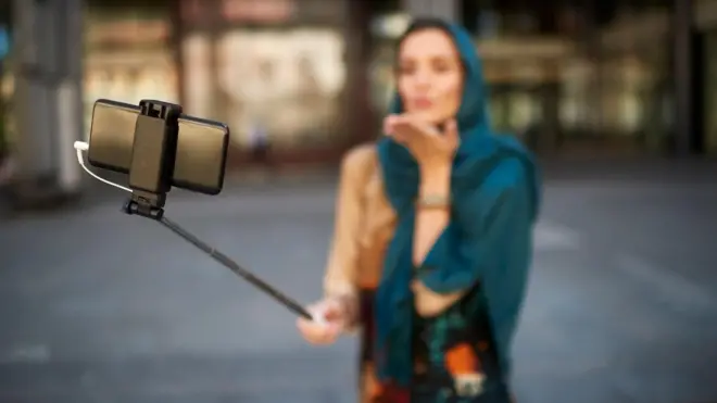 సెల్ఫీ స్టిక్తో వీడియో రికార్డ్ చేస్తున్న మహిళ