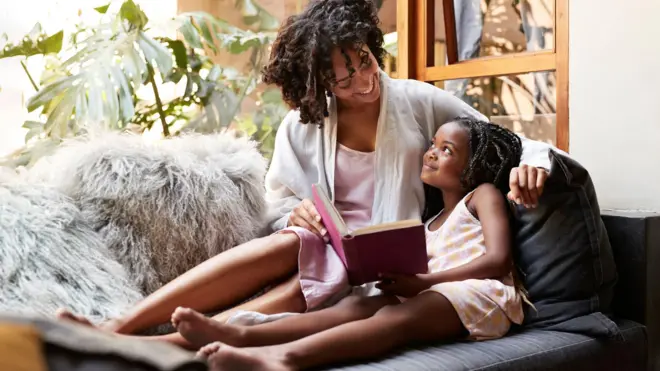 ከልጇ ጋር መጽሐፍ የምታነብ ሴት