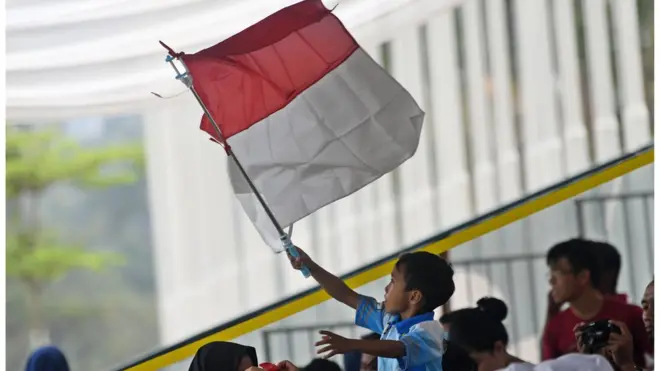 Seorang suporter cilik Indonesia mengibarkan bendera Merah Putih mendukung tim Indonesia di Gelora Bung Karno, Jakarta, Kamis (23/8).