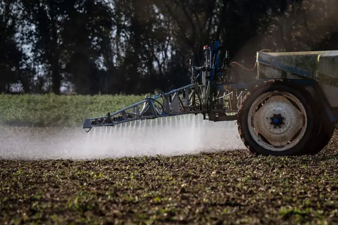 Trator aplica herbicida no em campo