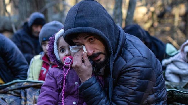 رجل مع طفل على الحدود البولندية