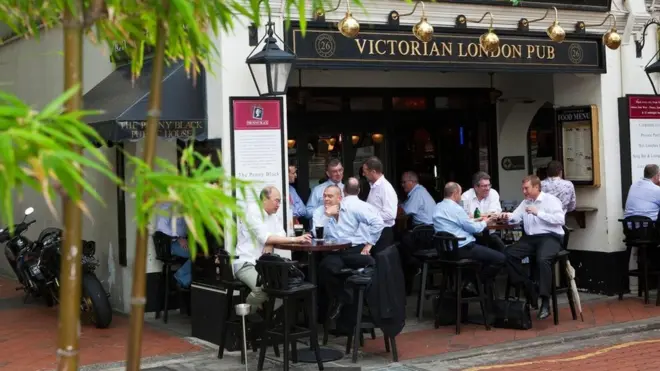 城市劳动者在新加坡驳船码头的英式酒吧饮酒