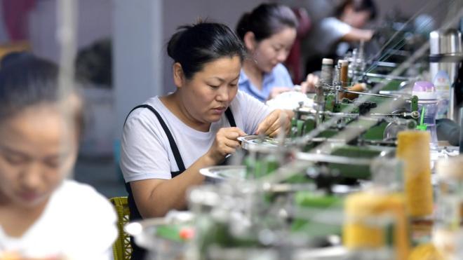 Women work at sewing machines in a factory in China in 2018
