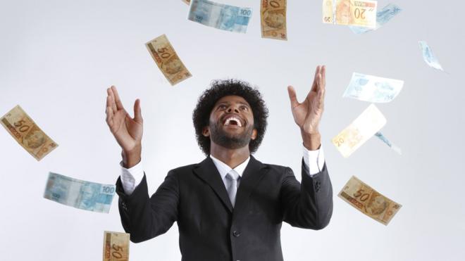Homem vendo dinheiro cair do céu
