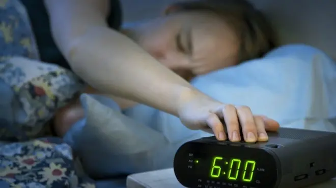 Женщина, отключающая будильник