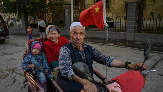 新疆阿克蘇街頭一家維吾爾人乘三輪車而過（11/9/2019）