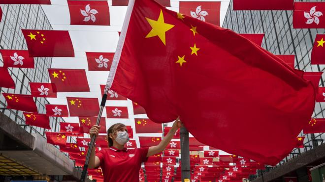 香港九龍尖沙咀東某購物商場外一位參與慶祝中共建黨百年活動女士在揮舞中國國旗（29/6/2021）