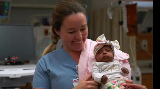 ممرضة تحمل الطفلة سيبي