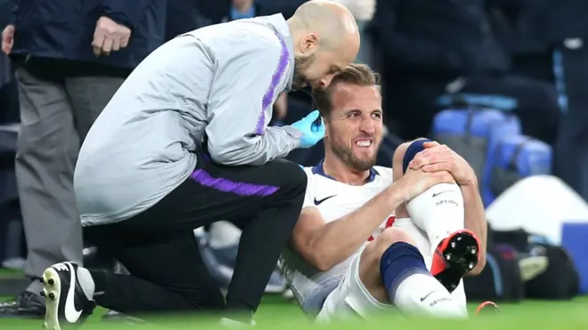 Harry Kane se faisant traiter par un membre du staff médical de Tottenham.