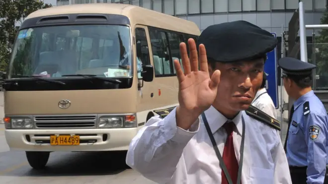 Un guarda de seguridad trata de detener a un periodista.