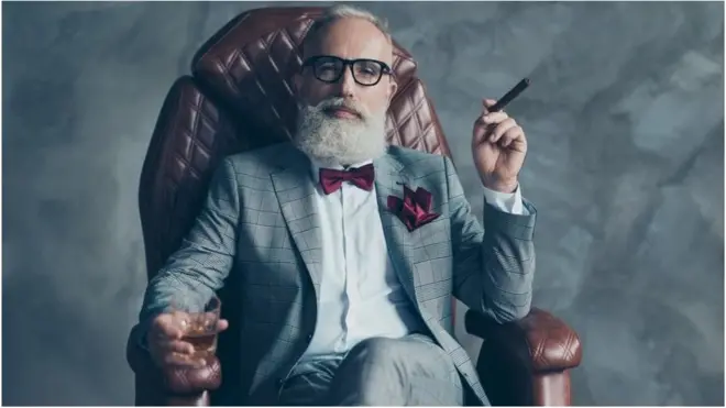 ወንበር ላይ ተቀምጦ በቄንጥ በማጨስ ላይ ያለ ሰው