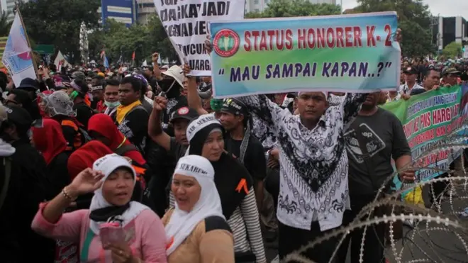 Guru honorer melakukan demonstrasi di depan Istana Presiden karena gaji yang rendah dan ketidakpastian kerja.