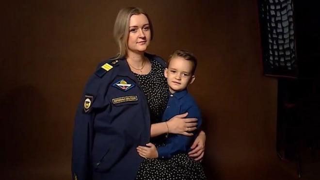 一名俄羅斯士兵的妻子披著他的制服拍照