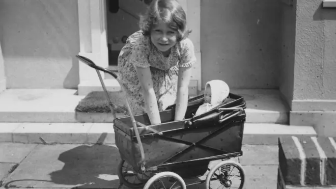 Princess Elizabeth playing with a doll in a toy pram