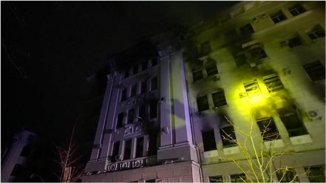 Ручной фонарик освещает здание в Харькове