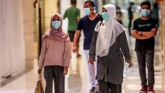 Warga di Medan mengenakan masker di tengahs seruan untuk tidak berkumpul.