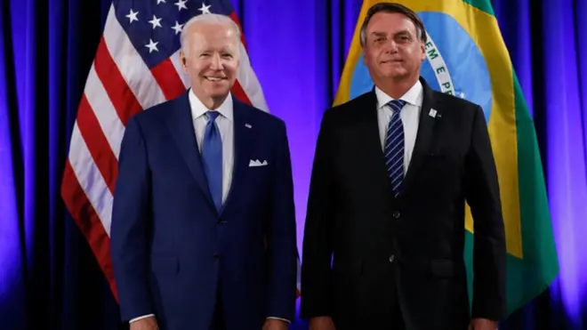 Biden e Bolsonaro. Atrás deles, bandeiras dos EUA e do Brasil