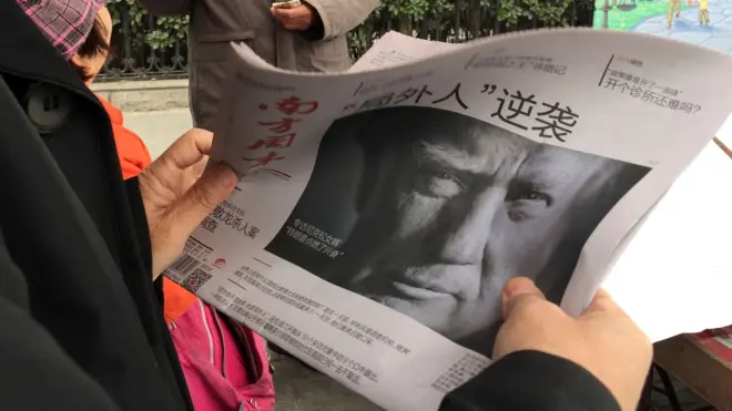 北京街頭一位市民在閲讀報道特朗普當選的《南方周末》(10/11/2016)