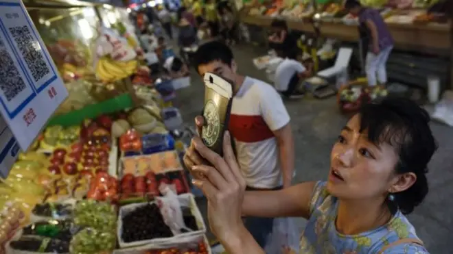 Thanh toán di động đã phủ sóng tới các chợ của TQ. Trong ảnh, một phụ nữ đang thanh toán bằng cách quét mã QR trên điện thoại