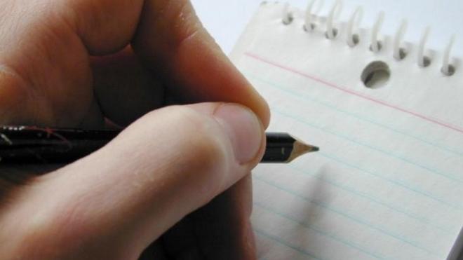 Generic image of person holding pencil over paper