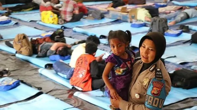 Seorang polisi wanita bermain dengan anak pengungsi Wamena di pengungsian di kota Merauke, Papua (03/10)