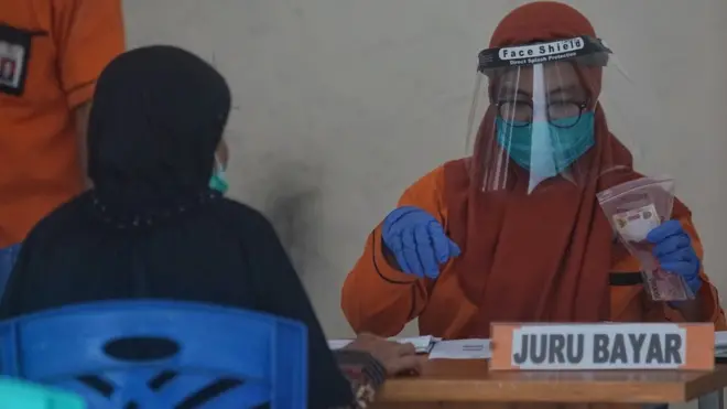 Petugas menyalurkan dana Bantuan Sosial (Bansos) bagi warga Kota Yogyakarta di Kantor Pos Yogyakarta, Sabtu (09/05).