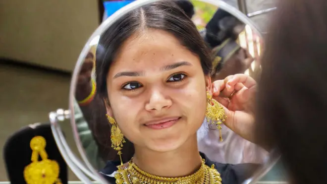 गहने पहनती युवती