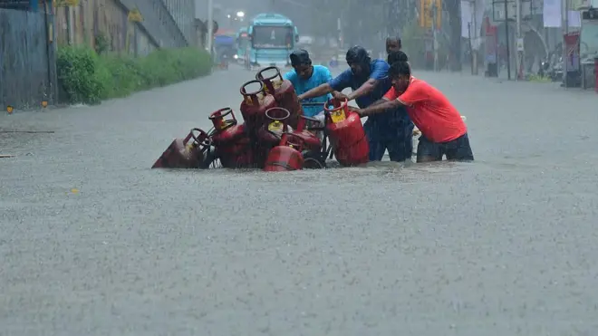 18 ऑगस्टरोजी मुंबईत साचलेल्या पाण्यातून सिलेंडर घेऊन जातानाचा फोटो
