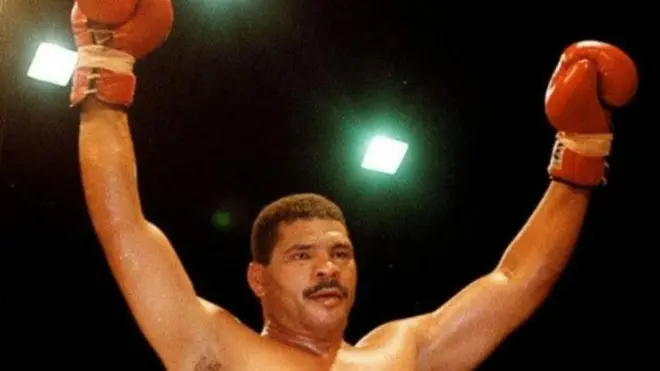 Maguila mais jovem, erguendo os braços com luva de boxe