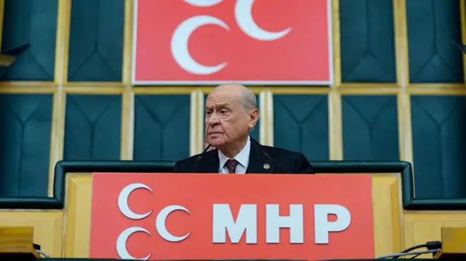 Bahçeli mhp logoları önünde konuşuyor