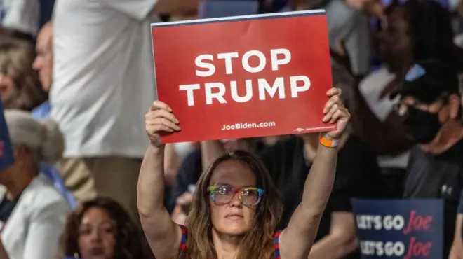 Apoiadoracrb e vila nova palpiteBiden segura cartaz contra Trump