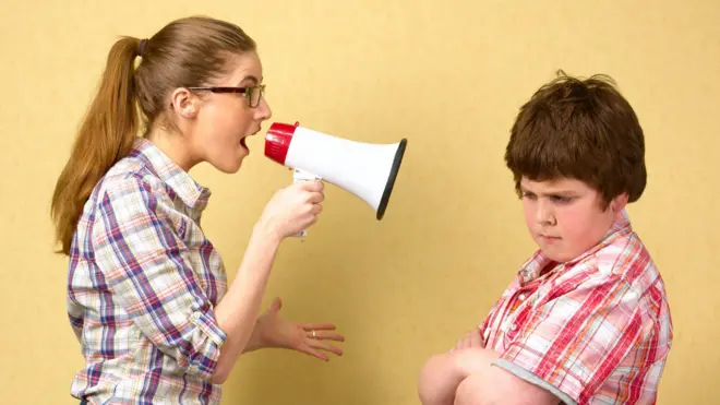 Сестра кричить на брата через мегафон - стокова фотографія