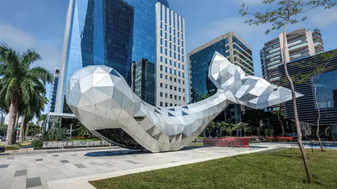 Escultura de baleia com prédios espelhados na Avenida Faria Lima, em São Paulo 