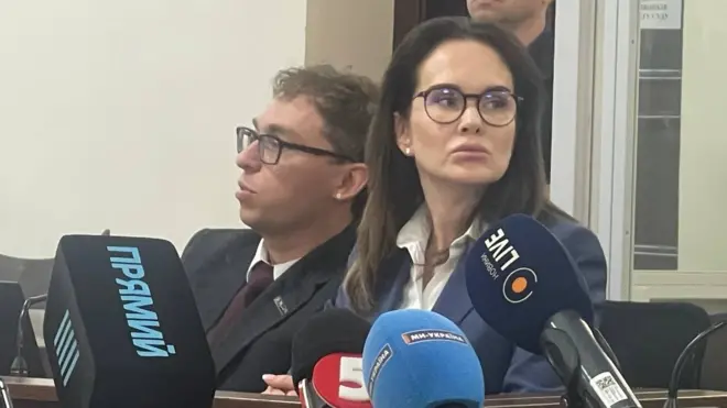 Ірина Мудра в окулярах і в синьому жакеті у суді
