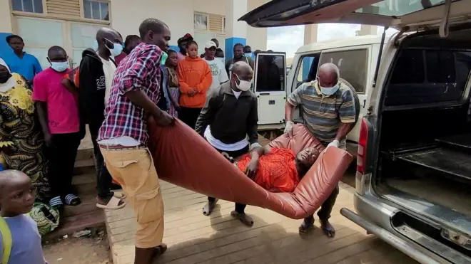 Umugabo utwawe kuri matola n'abagabo batatu bambaye udupfukamunwa, bamukuye mu modoka y'imbangukiragutabara, mu gihe abantu benshi babashungereye, ku bitaro bikuru by'i Bunia, mu ntara ya Ituri, muri Repubulika ya Demokarasi ya Congo, nyuma yuko hemejwe ikiza cya virusi ya Ebola yo mu bwoko bwa Bundibugyo. 