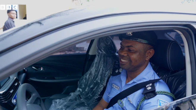 Police officer Sentome Obi inside im car gift