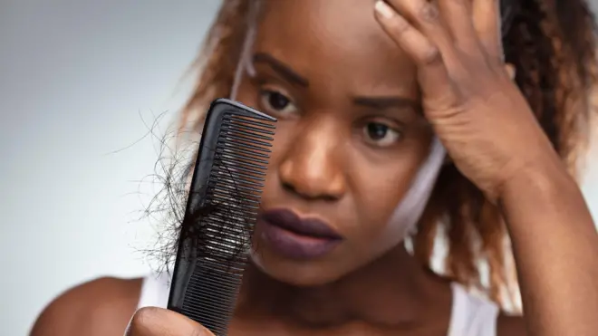 A woman shocked to see her hair stuck to a comb